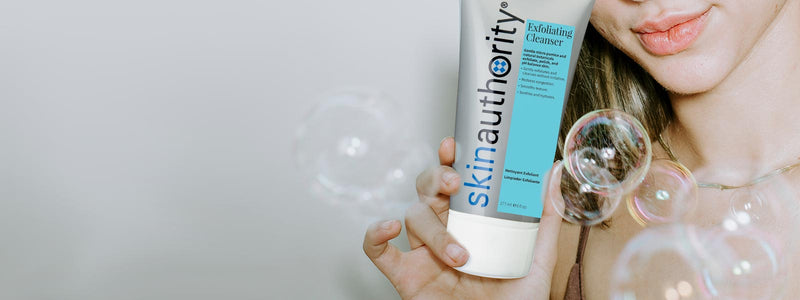Person holding a 'skin authority' product with bubbles in the foreground